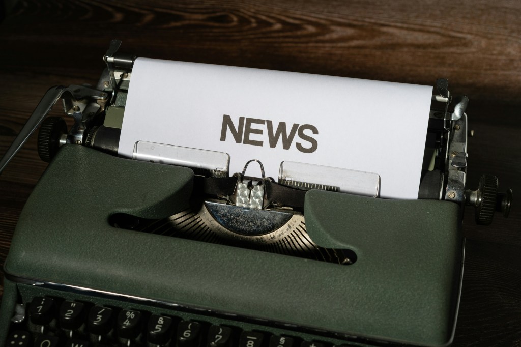 typewriter with news written on the text